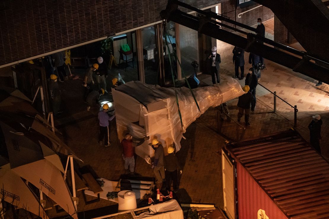 Workers remove part of the "Pillar of Shame" statue into a container at University of Hong Kong on December 23.