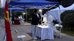 A resident undergoes a nucleic acid test for the Covid-19 coronavirus at a residental area that is under restrictions following a recent coronavirus outbreak in Xian, in China's northern Shaanxi province on December 23, 2021. - China OUT (Photo by AFP) / China OUT (Photo by STR/AFP via Getty Images)