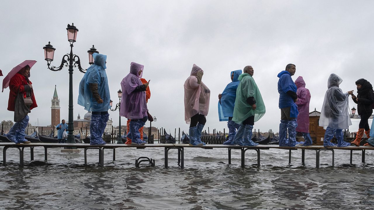 Tourists typically navigate Venice flooding on raised walkways.