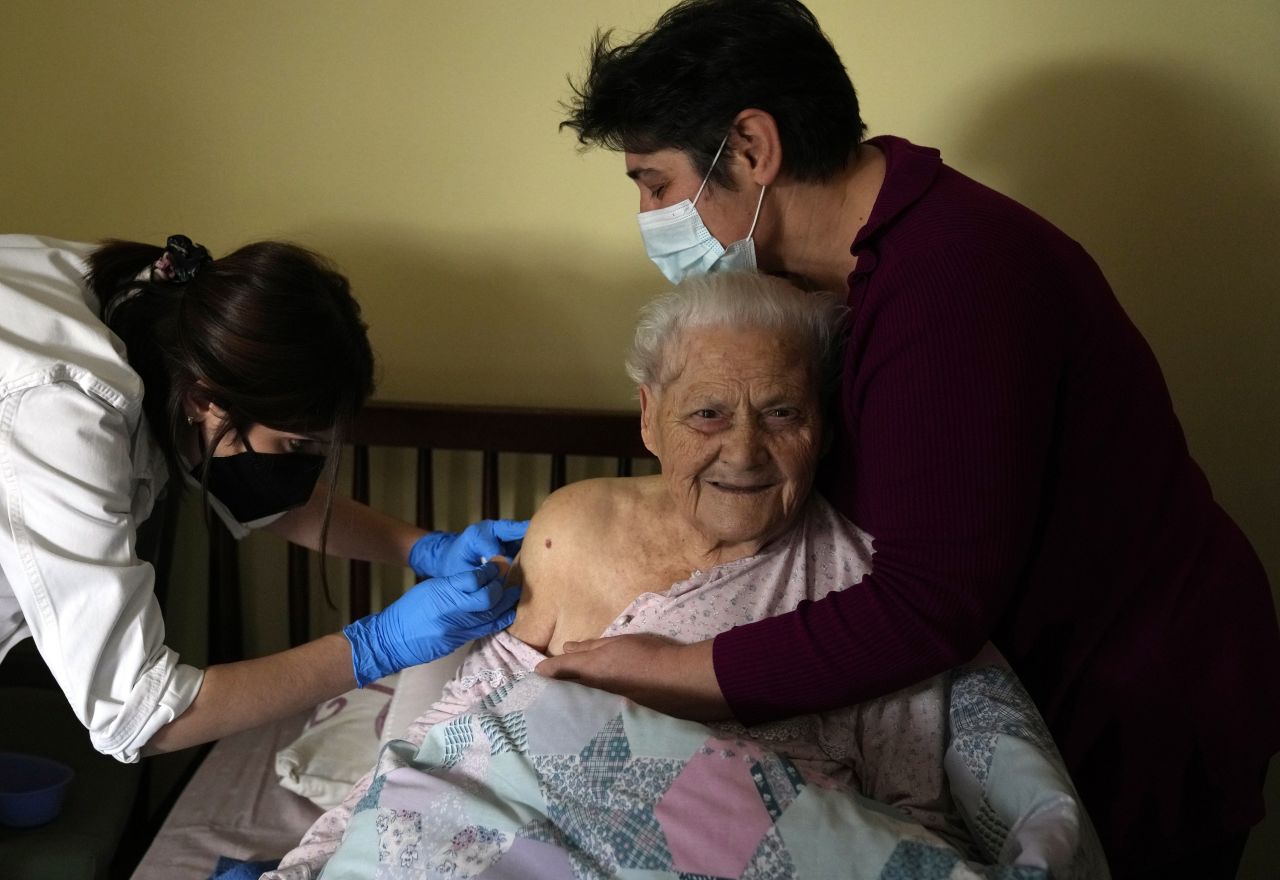 Georgia Bisti-Bavella, 97, smiles as she receives a booster of the Pfizer-BioNTech vaccine in Athens, Greece, on  December 22. Public health authorities in Greece have stepped up a campaign to deliver booster shots to seniors and people with mobility issues at home.