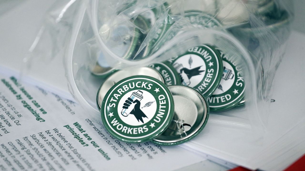 Pro-union pins sit on a table during a watch party for Starbucks' employees union election, Dec. 9, 2021, in Buffalo, N.Y. 