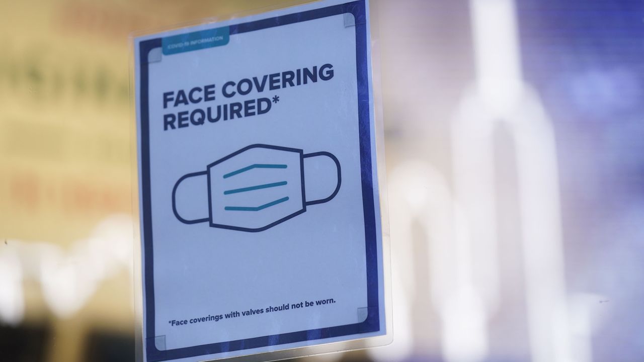 A sign reminds customers that masks are required in their store in New York, Monday, Dec. 13, 2021. 