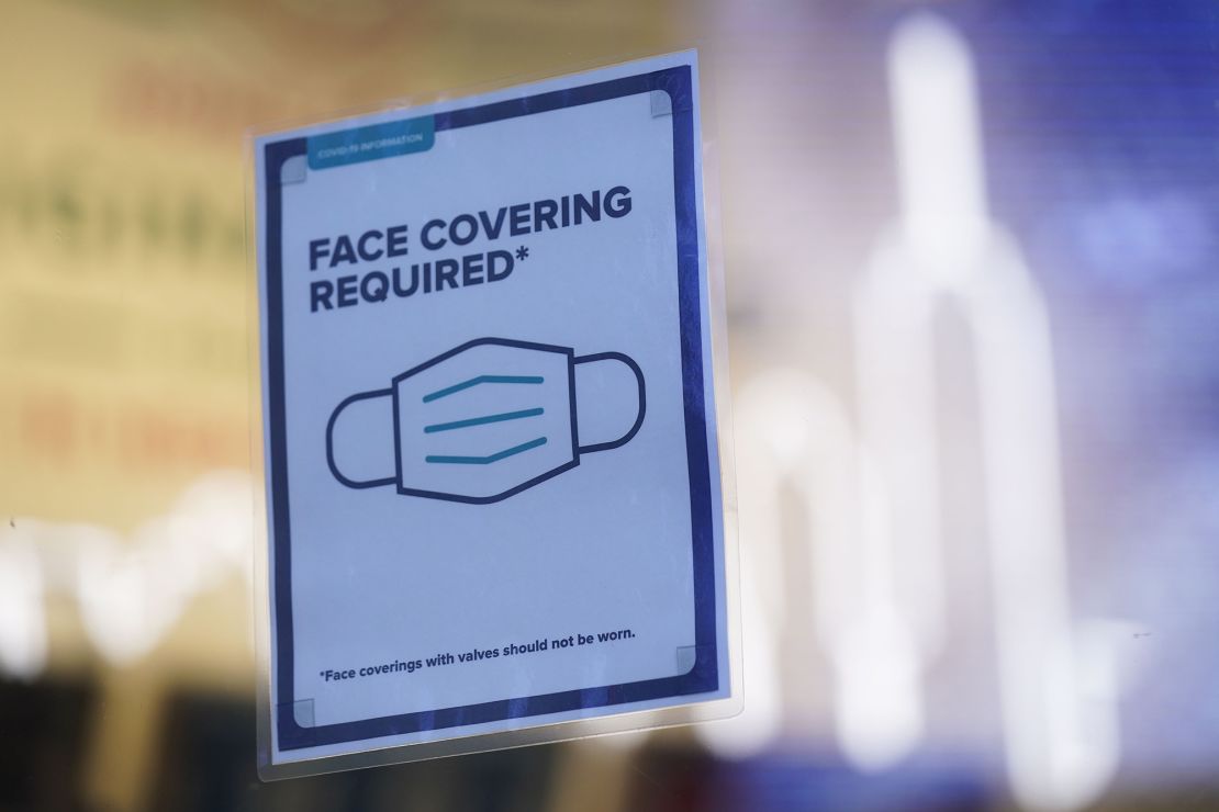A sign reminds customers that masks are required in their store in New York, Monday, Dec. 13, 2021.
