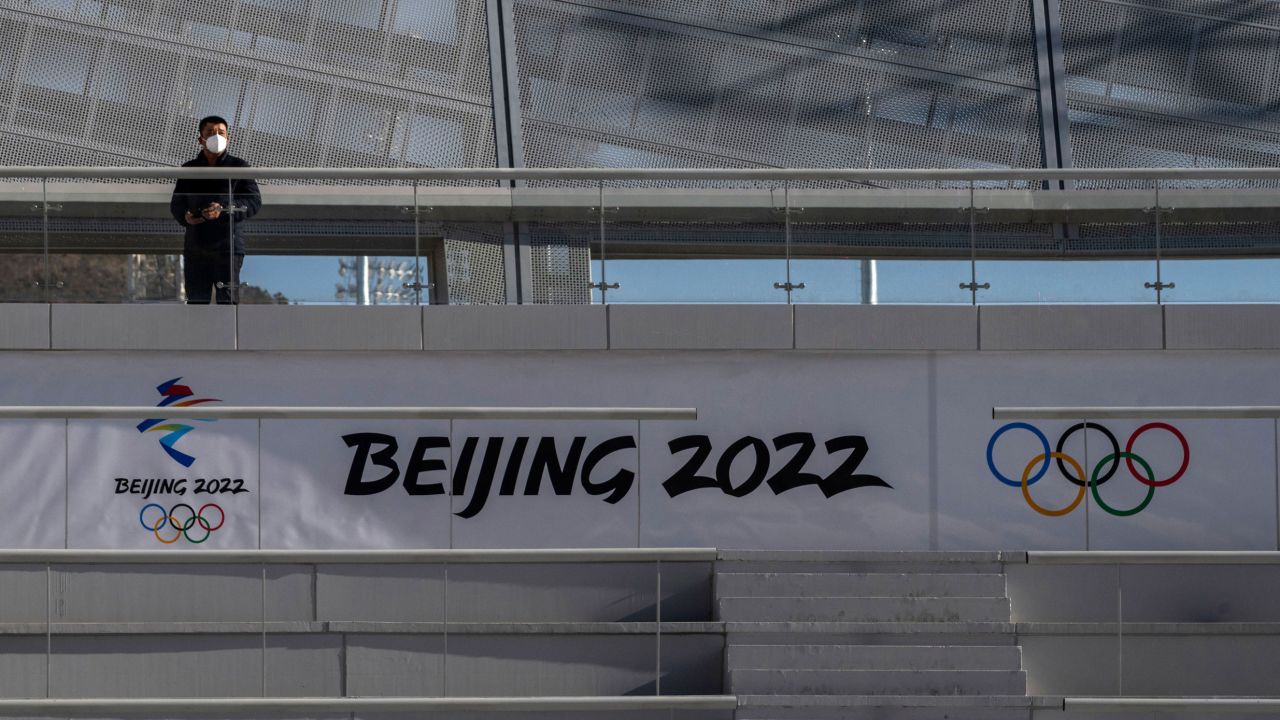 ZHANGJIAKOU, CHINA - DECEMBER 21: A worker stands in the grandstands near a logo in the finish area at the National Ski Jumping Center, that will host events during the Beijing 2022 Winter Olympics, during a media tour on December 21, 2021 in Chongli, Zhangjiakou, in Hebei province, northern China. The area will host a number of events for the Beijing 2022 Winter Olympics which are set to open on February 4th, 2022.(Photo by Kevin Frayer/Getty Images)