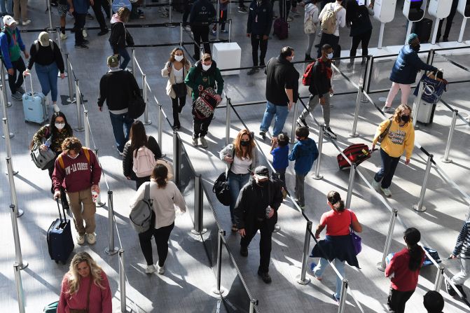 Travelers wait in a security checkpoint line at Orlando International Airport on December 23.