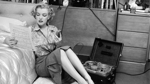 She was in several movies in 1950, including "The Asphalt Jungle" and "All About Eve." Seen here, Monroe is reading sheet music while sitting on a bedroom floor with a tape player on her side.