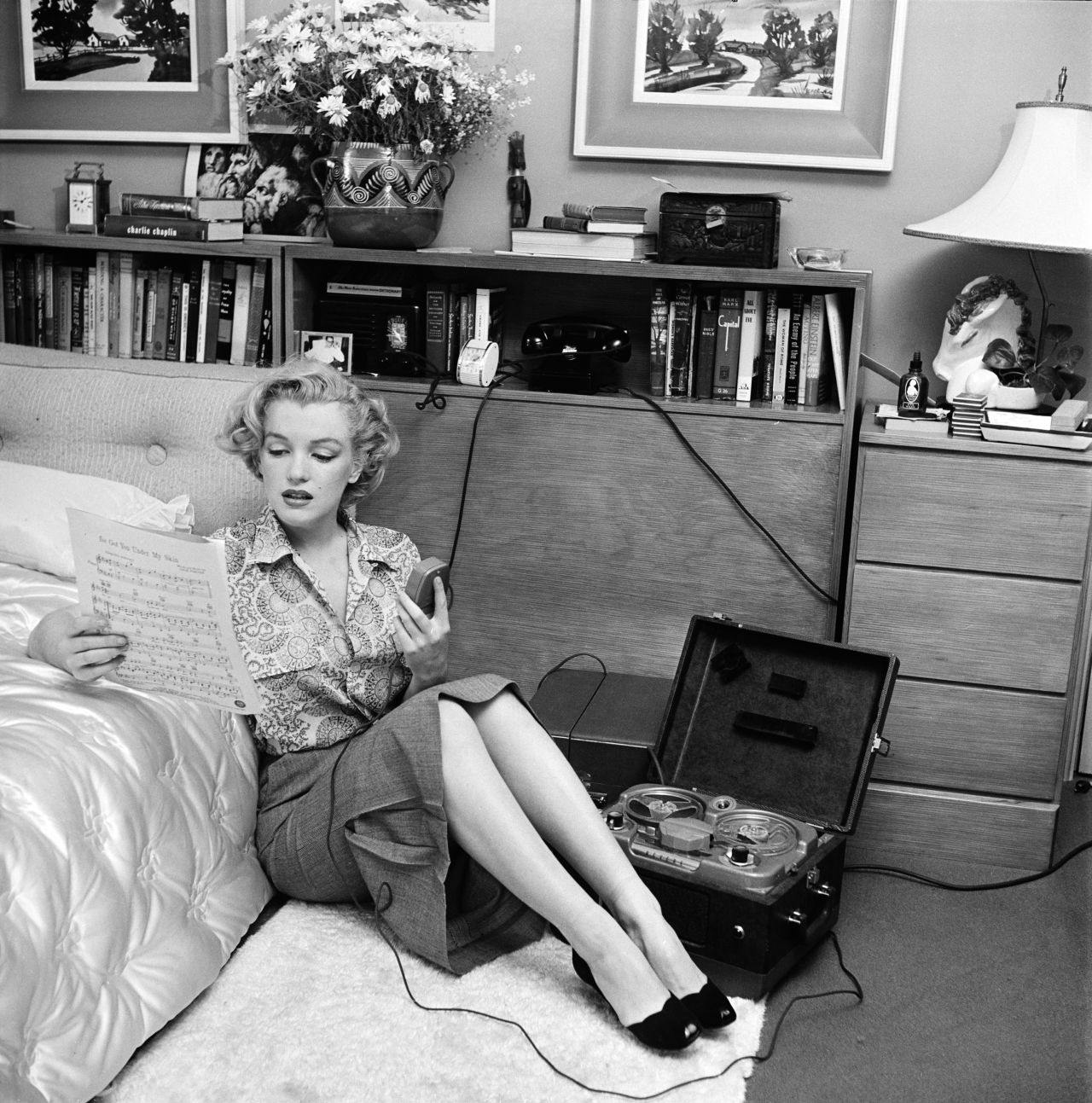 She was in several movies in 1950, including "The Asphalt Jungle" and "All About Eve." Seen here, Monroe is reading sheet music while sitting on a bedroom floor with a tape player on her side.
