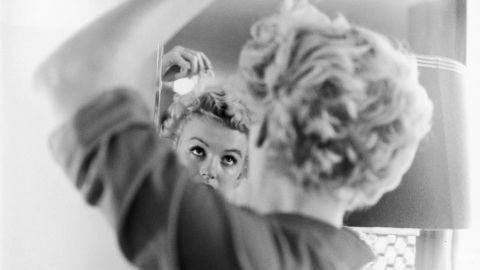 Monroe fixes her hair in front of a mirror in 1951. That year she had several supporting roles in comedies, including "As Young as You Feel," "Love Nest" and "Let's Make It Legal."<br /><br />"If you happen to have blonde hair, you're considered dumb. I don't know why that is. It's very -- I think it's a very limited view," Monroe said at the time.