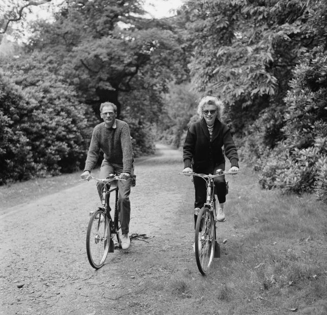 Monroe rides her bike with her third husband Miller. He's best known for writing the play Death of a Salesman.