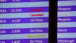 Canceled flights are noted in red on an electronic arrival board in the terminal of Denver International Airport, Friday, Dec. 24, 2021, in Denver. More than 200 flights were canceled by carriers out of Denver International because COVID-19 issues have created a shortage of workers. (AP Photo/David Zalubowski)