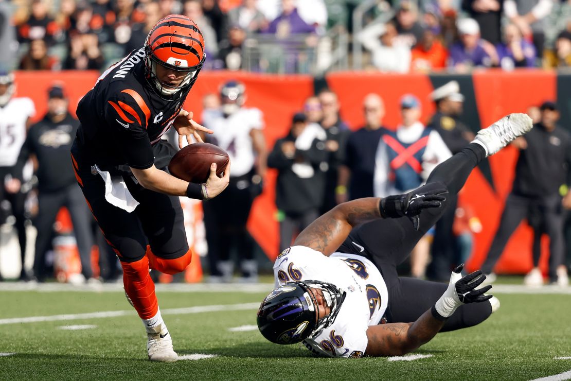 Burrow #9 of the Cincinnati Bengals avoids a tackle by Broderick Washington #96 of the Baltimore Ravens during the first quarter.