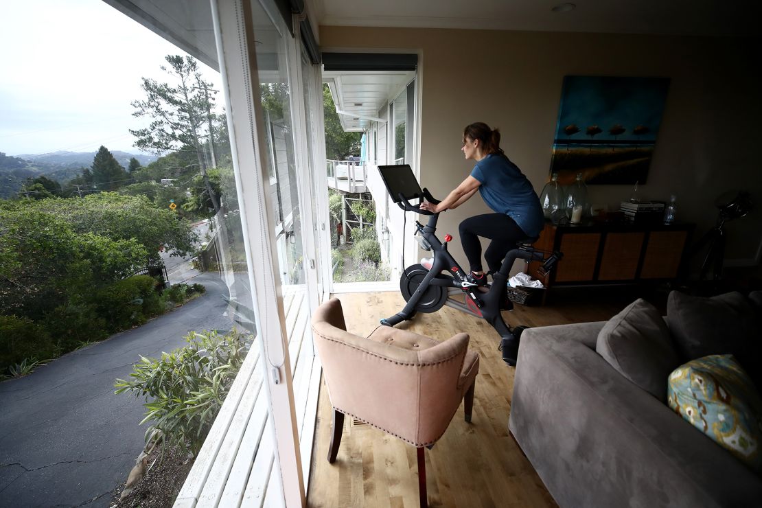 A person rides her Peloton exercise bike at home in San Anselmo, California, on April 6, 2020.