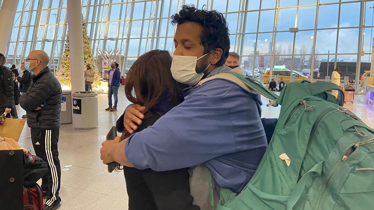 Fernando Espinoza hugs his mother Sara at JFK International Airport on December 27, 2021.