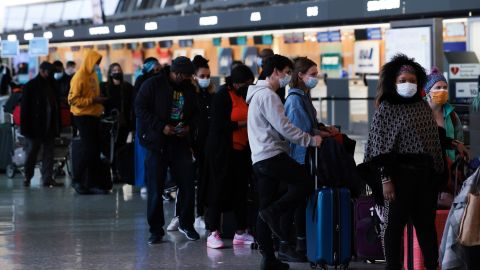 Passengers wait in line to check in for their flights at the Dulles International Airport in Dulles, Virginia, on Monday, December 27. 