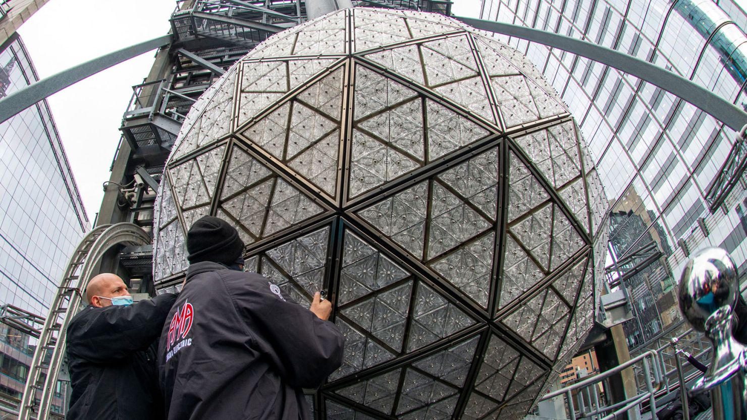 NEW YORK, NEW YORK - DECEMBER 27:  (EDITORS NOTE: Image captured with a fisheye lens.) Workers install 192 new Waterford Crystal triangles featuring this year's 'Gift of Wisdom' design on December 27, 2021 in New York City. The 12-foot in diameter, 11,875 pounds ball is covered in a total of 2,688 Waterford Crystal triangles which are bolted to 672 LED modules. On December 23rd, Mayor Bill de Blasio announced that New Year's Eve in Times Square will be limited to 15,000 socially distanced visitors that will be required to be fully vaccinated due to a rise in COVID-19 cases. (Photo by Alexi Rosenfeld/Getty Images)