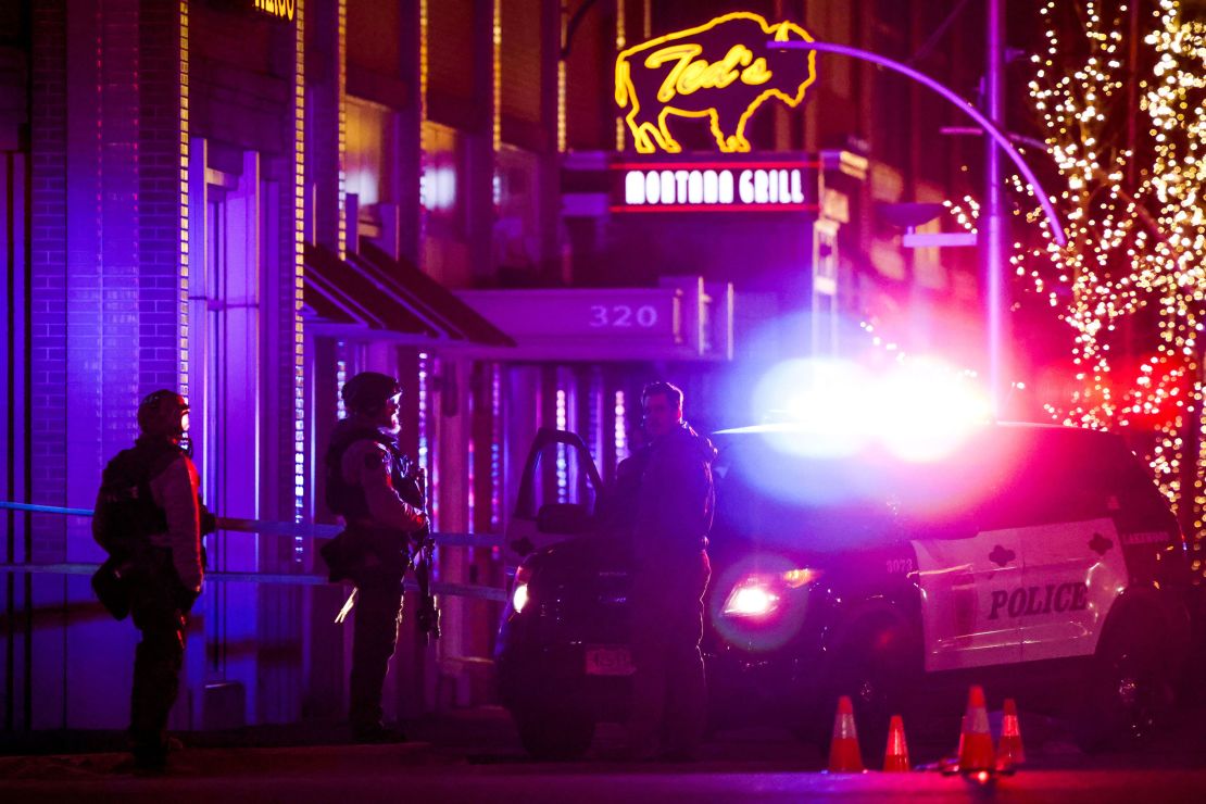 Police stand outside a Lakewood, Colorado, shopping center where the suspected gunman was killed.