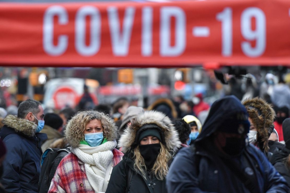 People wait in line for Covid-19 tests Monday at a mobile testing site in New York's Times Square.