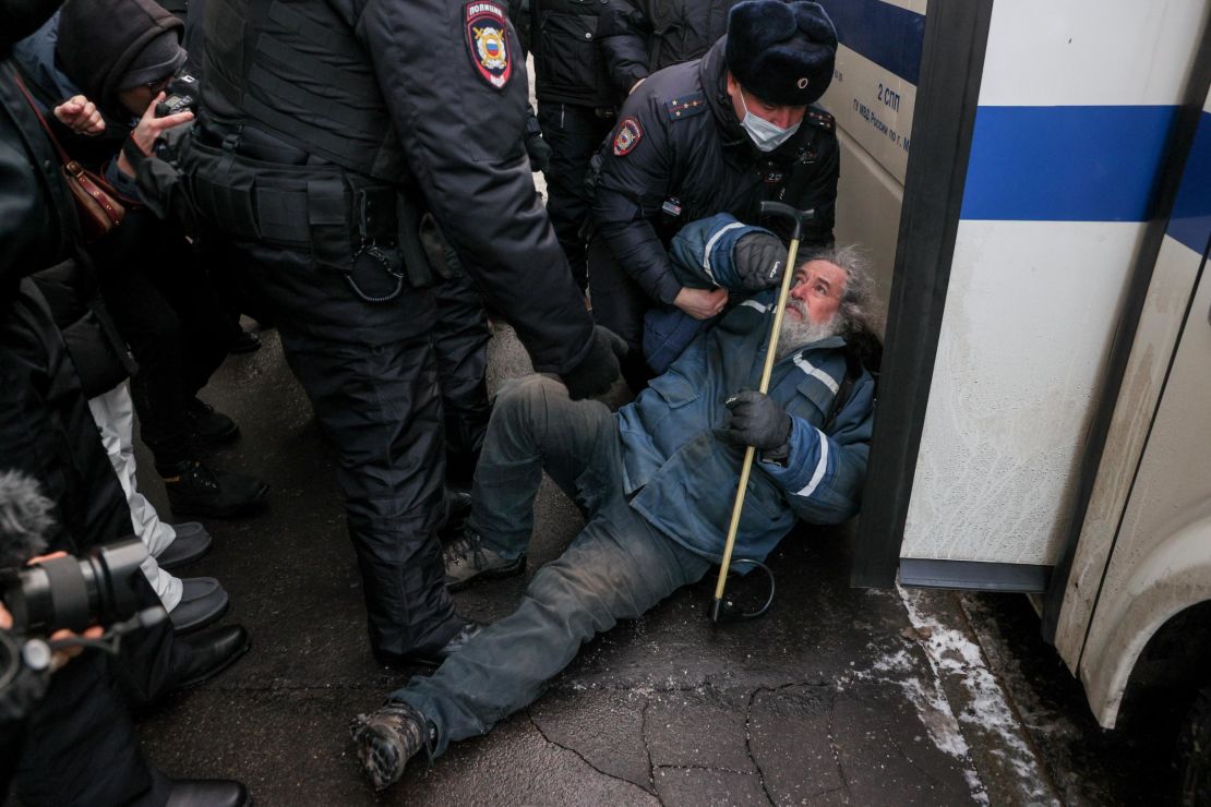 A Memorial supporter is seen with law enforcement officers outside the Russian Supreme Court.