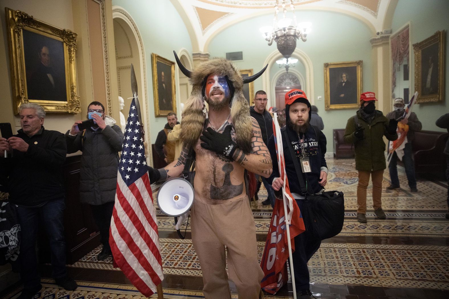 <a href="https://www.cnn.com/2021/01/07/us/insurrection-capitol-extremist-groups-invs/index.html" target="_blank">One of the most recognizable figures in the crowd</a> was a man in his 30s with a painted face, fur hat and a helmet with horns. The protester, Jacob Chansley — known by followers as the QAnon Shaman — quickly became a symbol of the bizarre and frightening spectacle. In the months leading up to the riot, Chansley had been a regular presence at pro-Trump protests in Arizona, including demonstrations outside the Maricopa County vote-counting center. In November 2021, <a href="https://www.cnn.com/2021/11/17/politics/jacob-chansley-qanon-shaman-january-6-sentencing/index.html" target="_blank">he was sentenced to 41 months in prison</a> for his role in the Capitol riot.