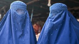 Afghan burqa-clad women are pictured at a market in Kabul on December 20, 2021.