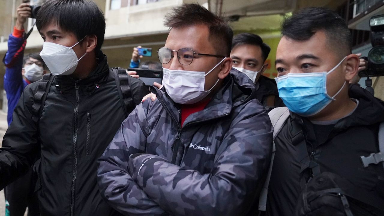 Senior editor of "Stand News" Ronson Chan, center, is taken away by police officers in Hong Kong, Wednesday, December 29, 2021. 