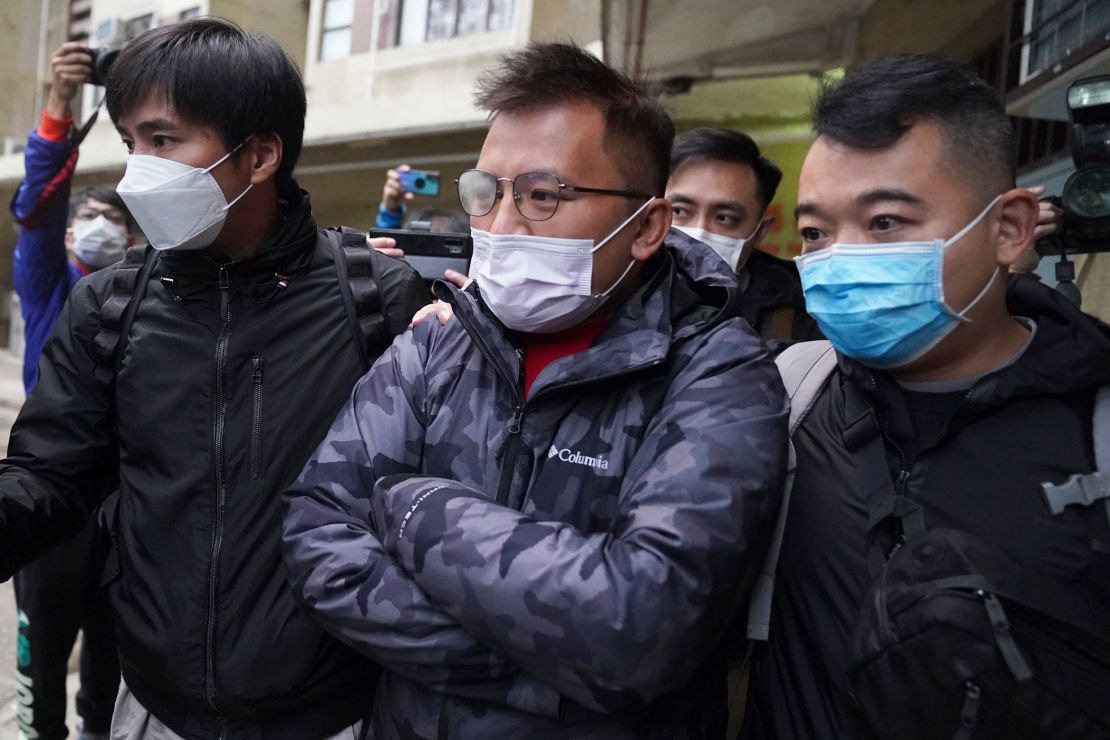 Senior editor of "Stand News" Ronson Chan, center, is taken away by police officers in Hong Kong, Wednesday, December 29, 2021. 