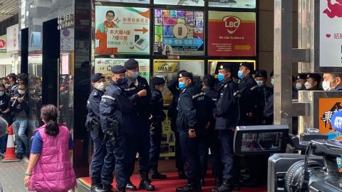 Police officers stand guard during a raid at the Stand News office in Hong Kong.