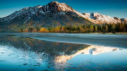 Langille Mountain with its reflection obscured in a partially frozen Kenai Lake in Alaska in September.