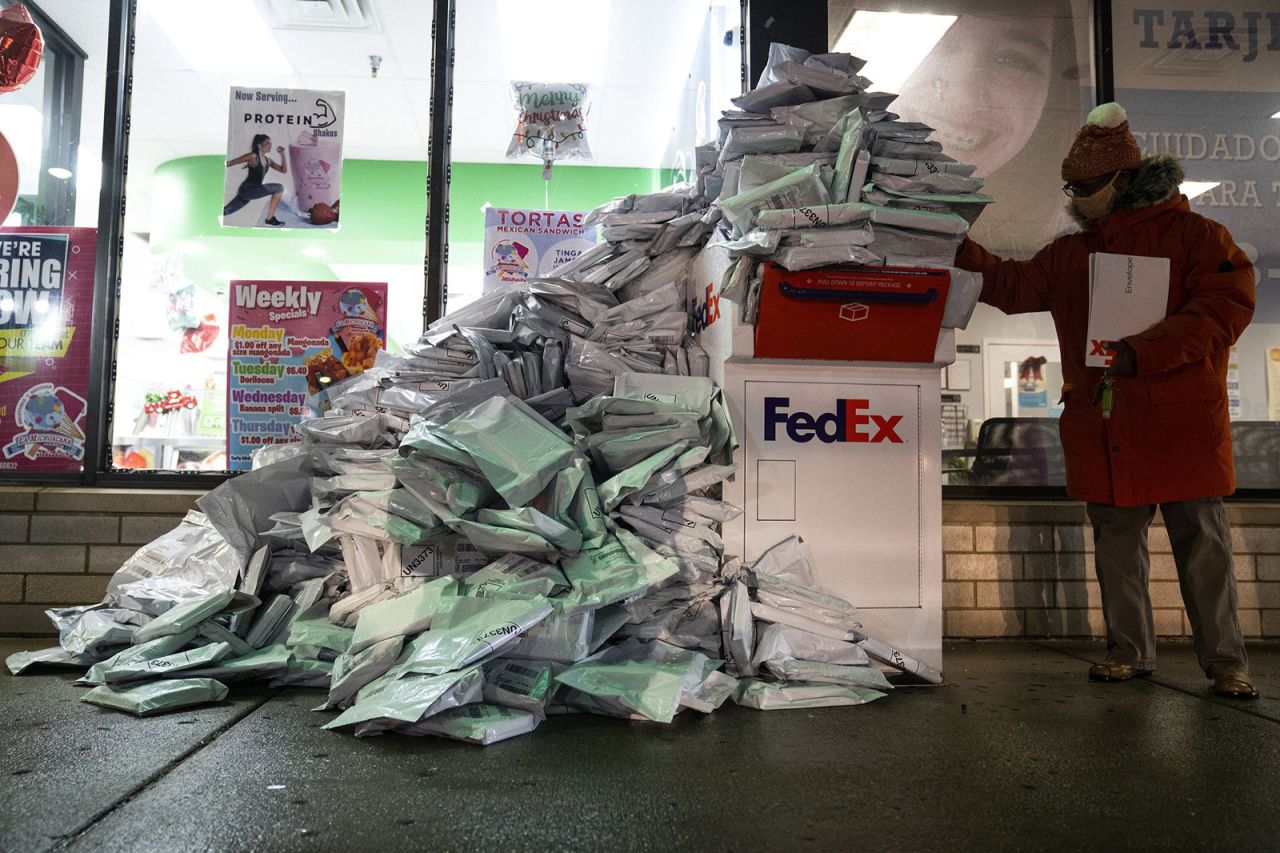 At-home Covid-19 tests, taken by Chicago Public Schools students, are piled up at a FedEx drop-off box in the neighborhood of West Elsdon on Tuesday, December 28. The school system extended the return deadline to December 30 and expanded drop-off sites.