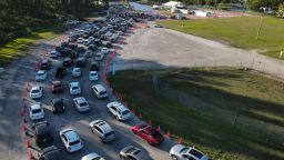 In this photo taken by a drone, cars wait in long lines at a drive-up COVID-19 testing center at Tropical Park, Wednesday, Dec. 29, 2021, in Miami. (AP Photo/Rebecca Blackwell)