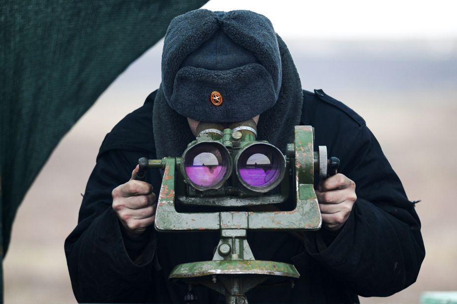 A Russian serviceman looks through binoculars as he takes part in drills at the Kadamovskiy firing range on Tuesday, December 14.