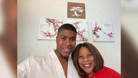 Andrew Oglesby (left) with his mom, CNN's Christy Oglesby (right), have a shared passion for watching and discussing "Cobra Kai." They are shown below the Miyagi-do and Japanese-themed art she selected as a nod to "The Karate Kid."