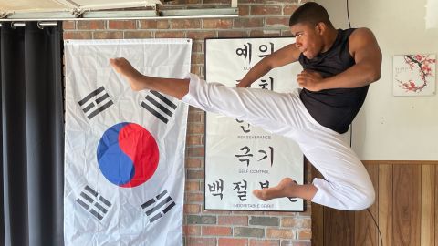 In the pandemic, college senior Andrew Oglesby shifted his tae kwon do training to his home garage, which CNN's Christy Oglesby, his mom, transformed into a Korean dojang or training hall. He demonstrates a flying side kick.