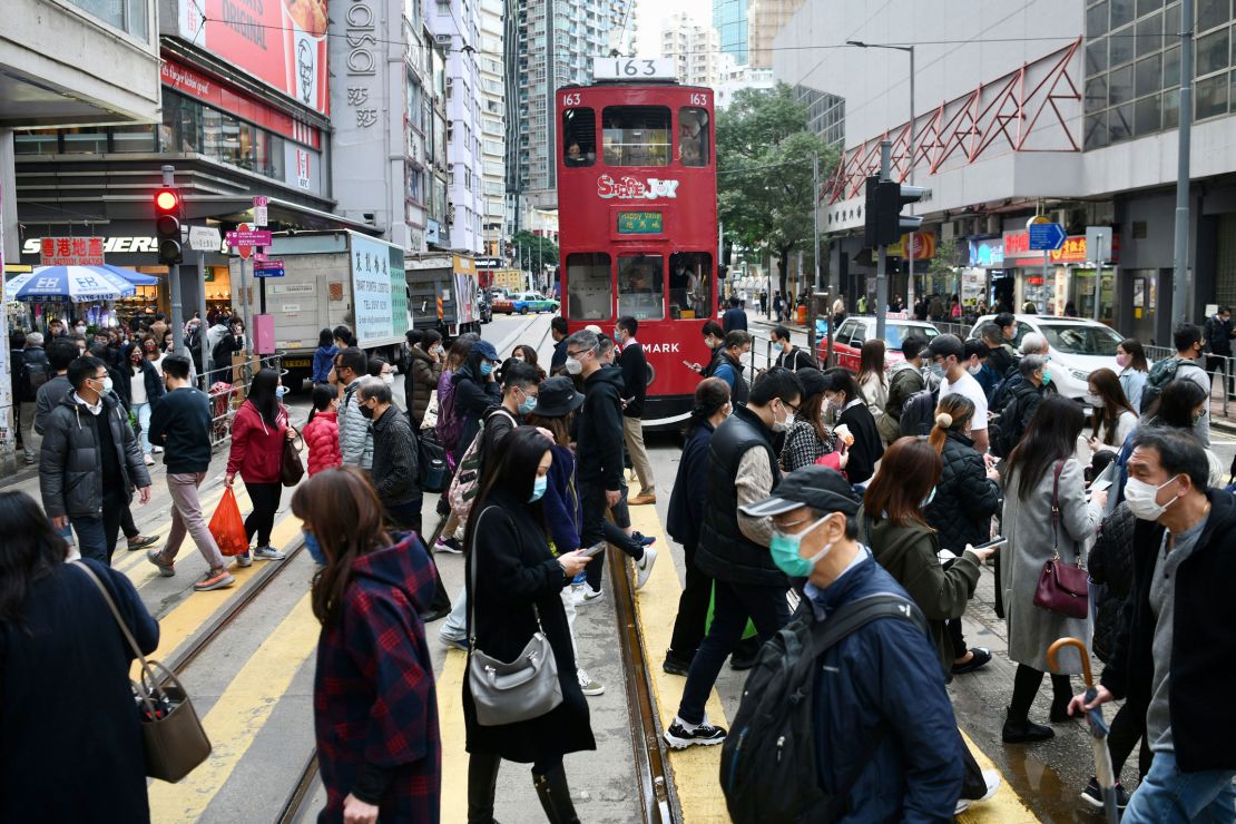 People wearing face masks cross a street in Hong Kong on December 21.