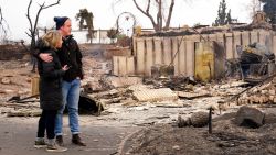 Christian Harrison and Deb Harrison examine the damage after the wildfire in Louisville, Colorado.