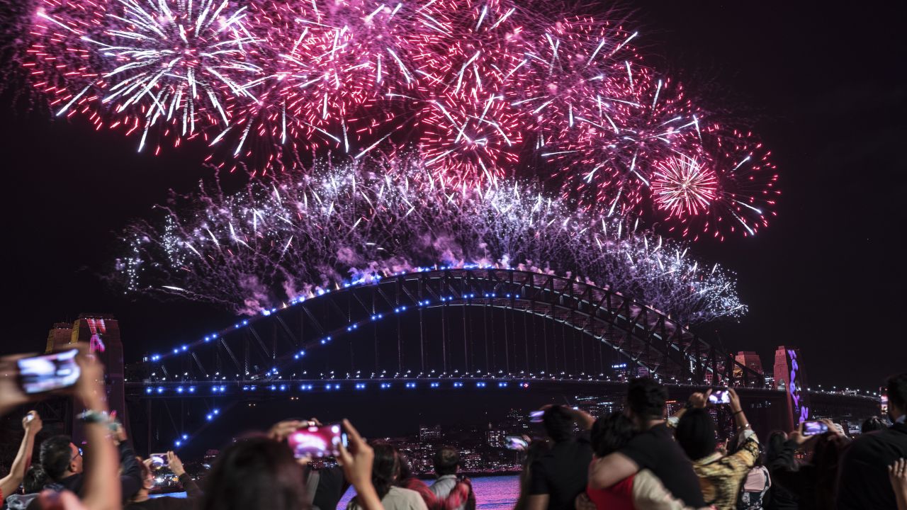 SYDNEY, AUSTRALIA - JANUARY 01: Fireworks light up the sky over Sydney Harbour as the clock strikes midnight on January 01, 2022 in Sydney, Australia. New Year's Eve celebrations continue to be somewhat different as some COVID-19 restrictions remain in place due to the ongoing coronavirus pandemic.  There were 21,151 news cases of COVID-19 recorded in New South Wales on the final day of 2021, setting a new record for the Australia's most populous state (Photo by Brook Mitchell/Getty Images)
