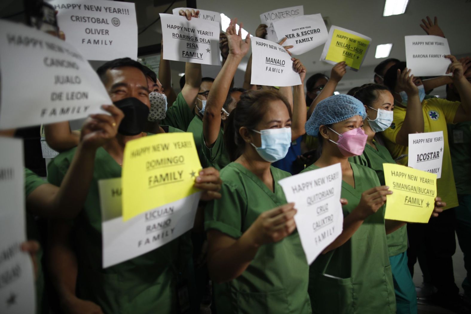 Doctors and nurses hold up signs at a hospital in Quezon, Philippines.