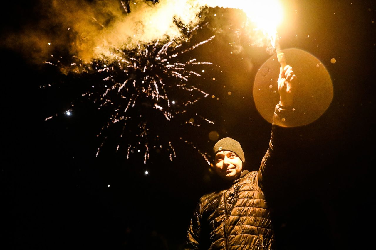 A man holds a flare while celebrating in Krakow, Poland.