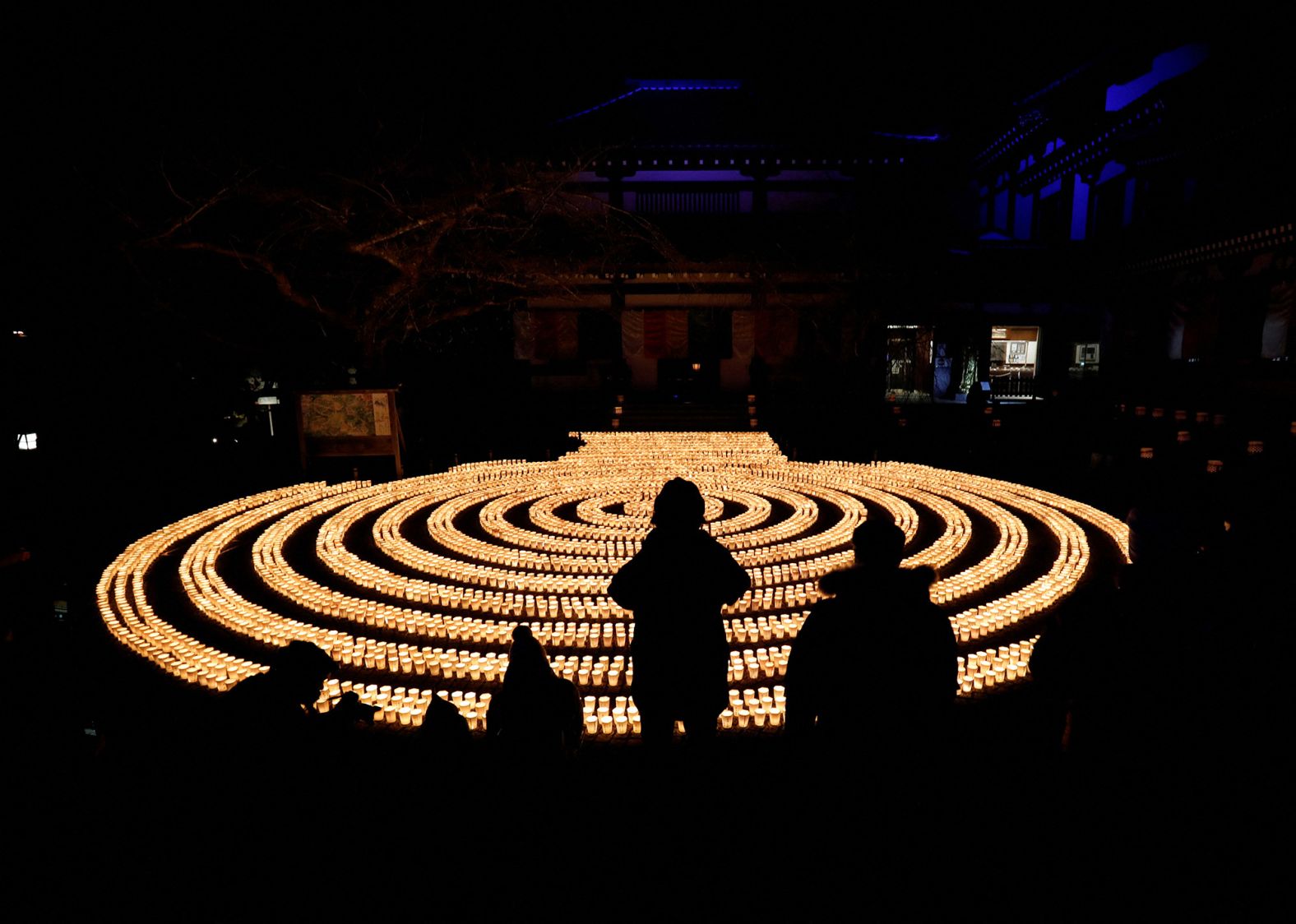 People observe candles lit to bring luck in the upcoming New Year at the Hasedera Buddhist temple in Kamakura, Japan, south of Tokyo.