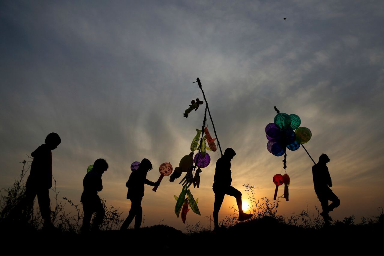 Balloon vendors walk back home as the sun sets in Jammu, India.