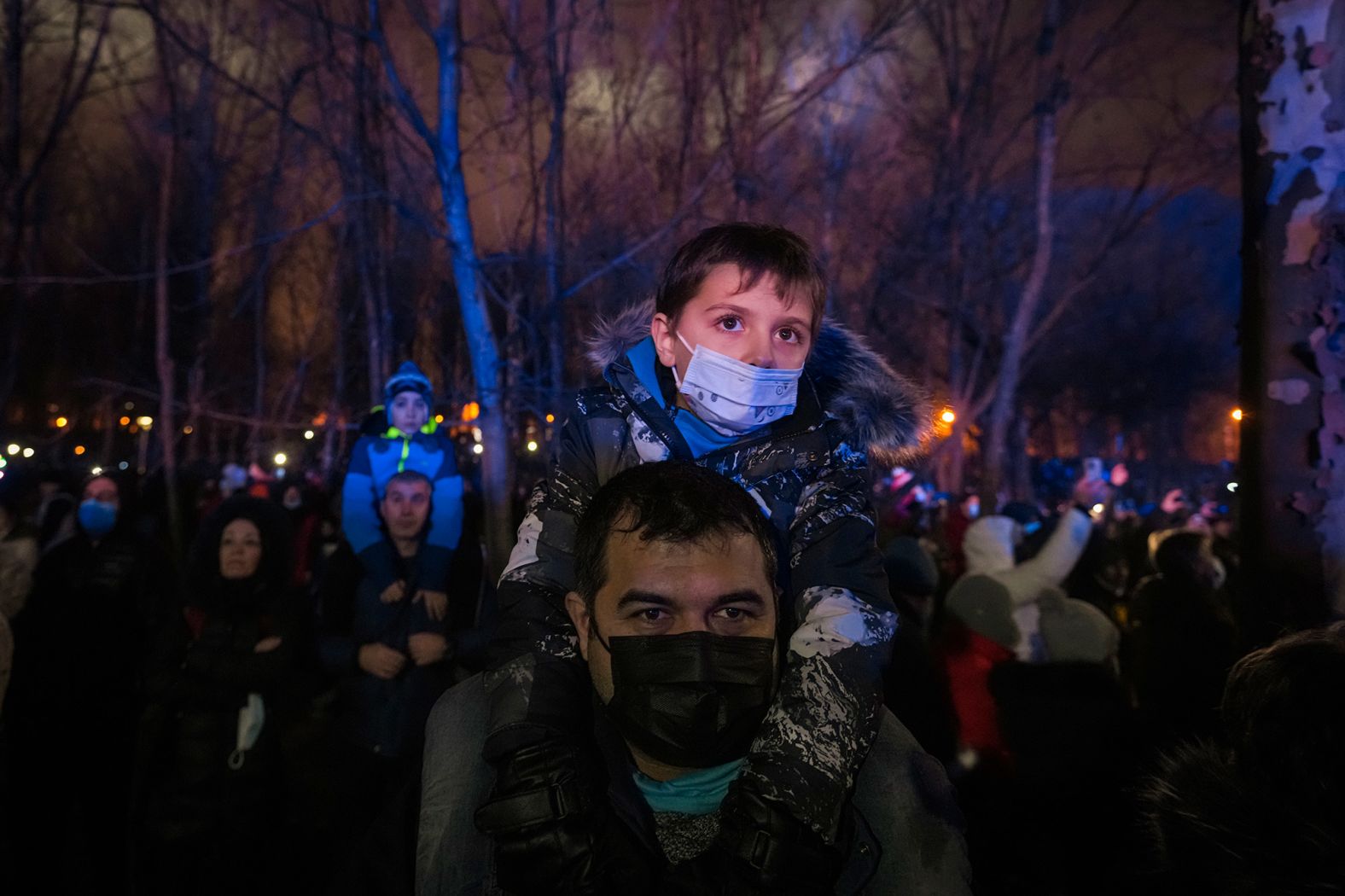 A man holds a child on his shoulders while waiting for the start of a fireworks show in Bucharest, Romania.