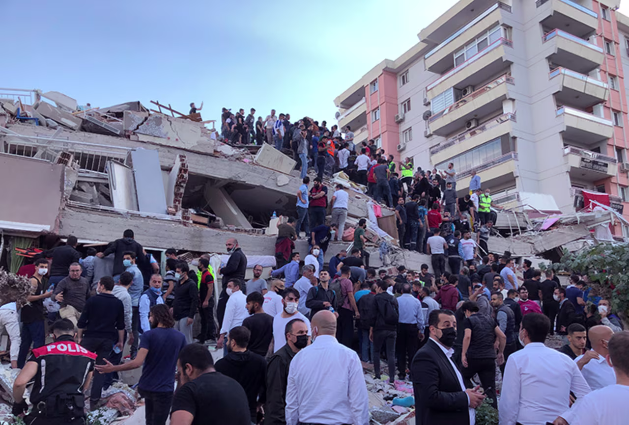 Rescue workers and local residents try to reach people trapped in the debris of a collapsed building in Izmir, Turkey, Friday, Oct. 30, 2020.