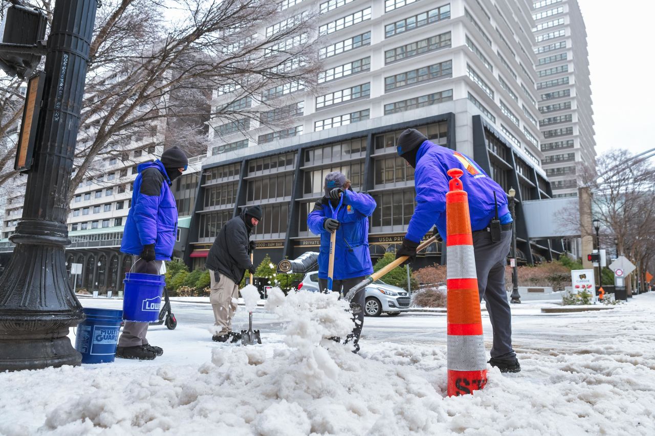 City workers use shovels to chip away at ice on the sidewalk in downtown Louisville on February 11, 2021 in Louisville, Kentucky.