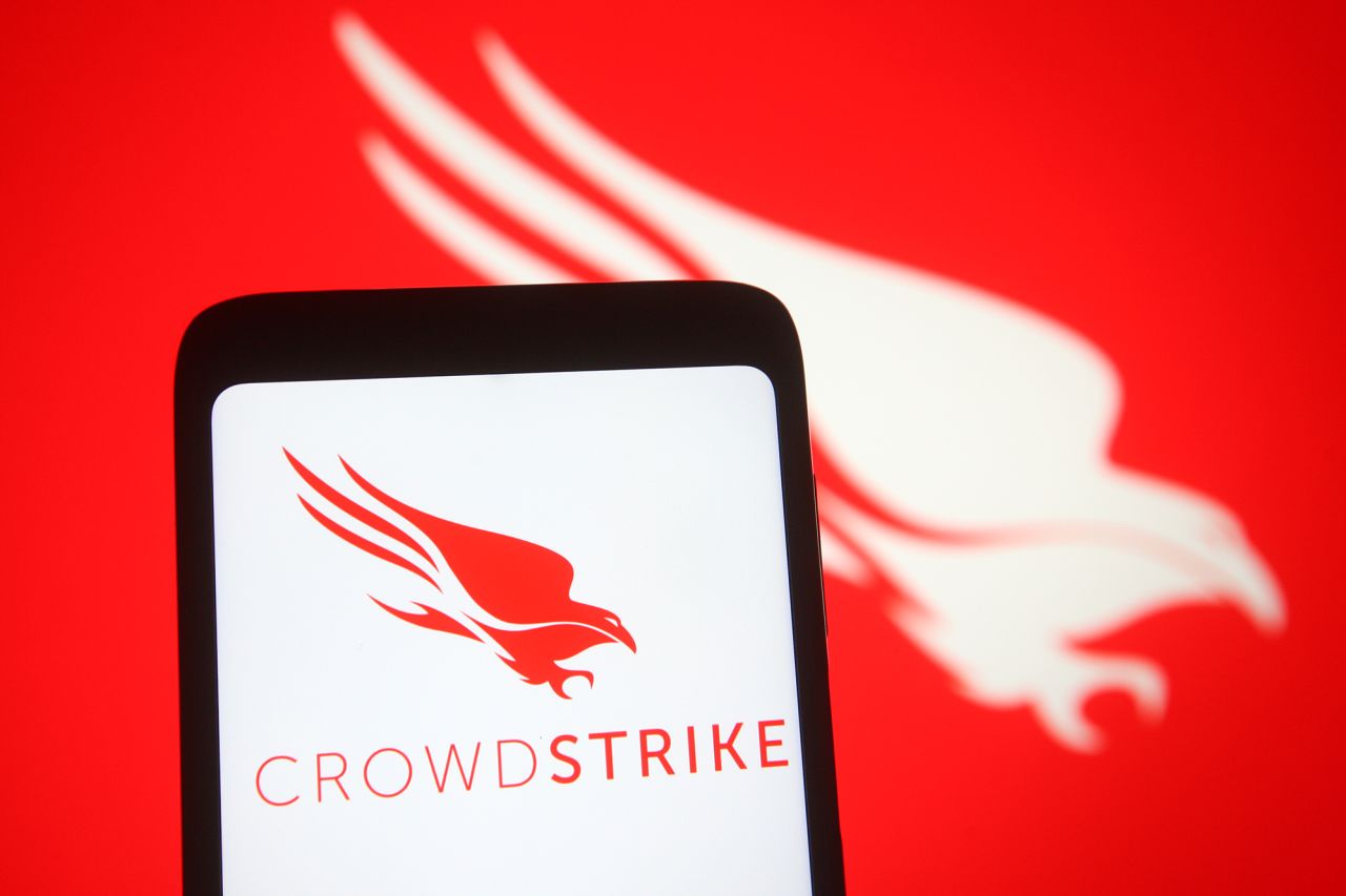 CrowdStrike logo of an US cybersecurity technology company is seen on a smartphone and a screen on March 15, 2021.