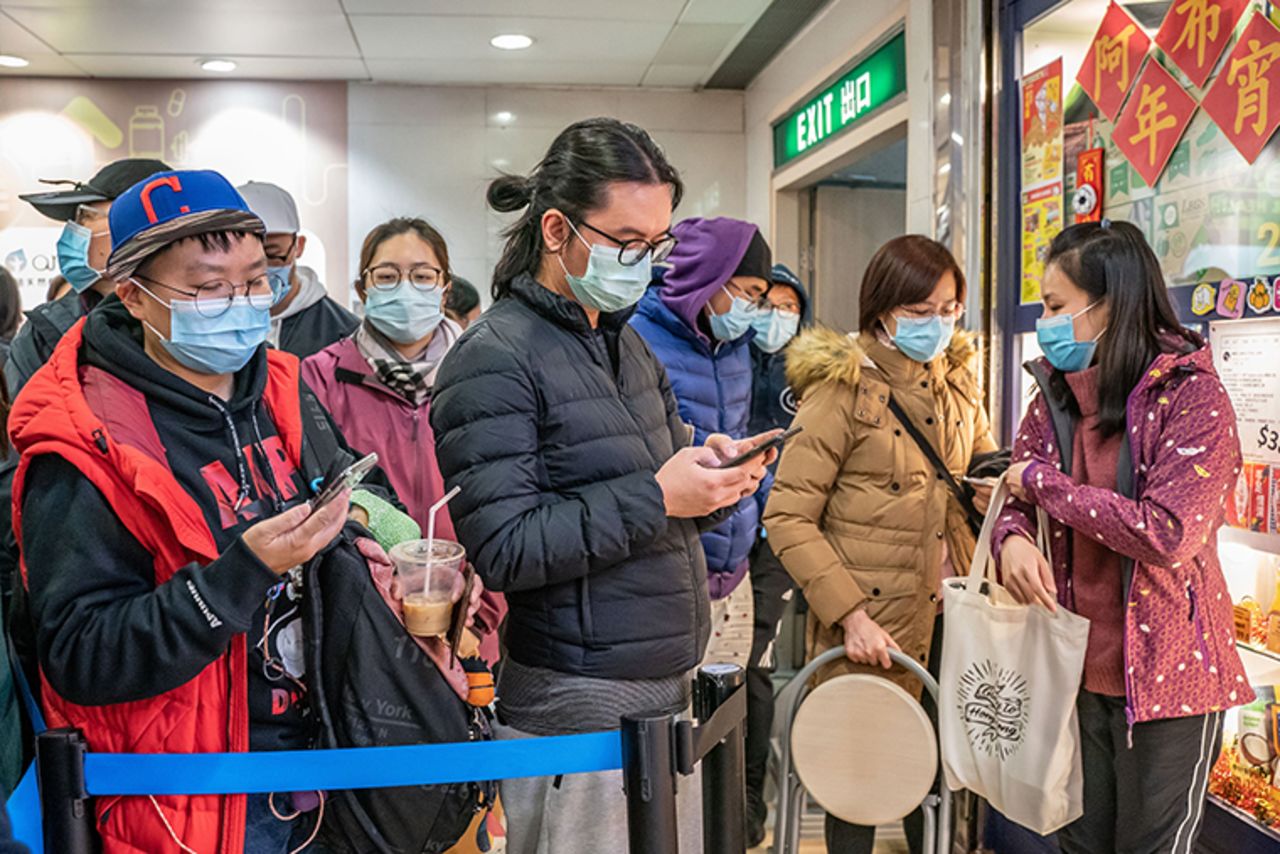 People wait in line to purchase surgical masks in a  Hong Kong shopping mall on January 29.