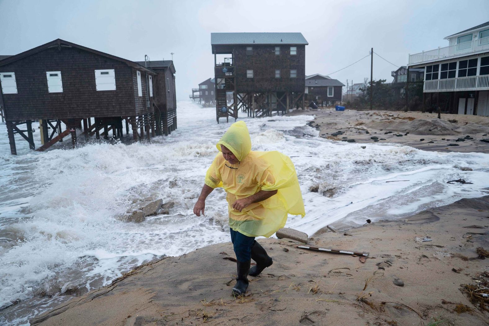 A man walks past houses at risk of collapse during a storm in Buxton, North Carolina, on Sunday, October 12. Coastal flooding and wind-whipped rain hit the mid-Atlantic and Northeast coastline as an <a href="index.php?page=&url=https%3A%2F%2Fwww.cnn.com%2F2025%2F10%2F12%2Fweather%2Fnoreaster-coastal-storm-flooding-wind-climate">impactful nor’easter crawled up the East Coast</a>.
