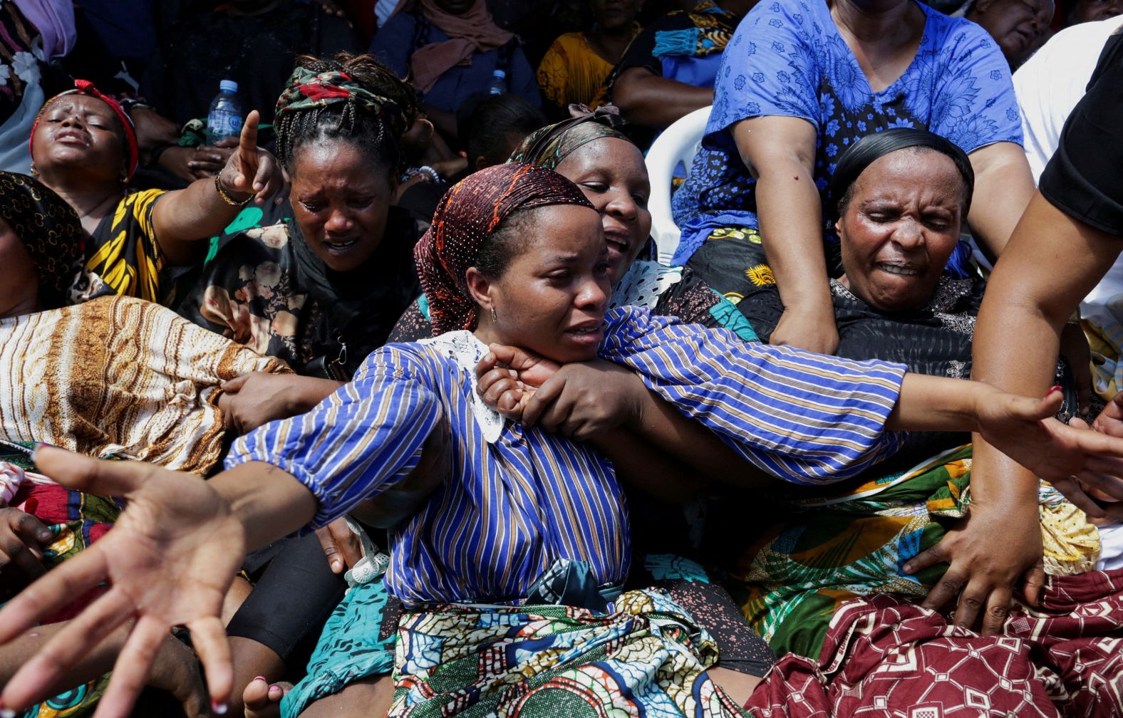 People attend a farewell ceremony in Dar es Salaam, Tanzania, on Monday, November 18, mourning their relatives who were killed when a four-story building collapsed the day before.