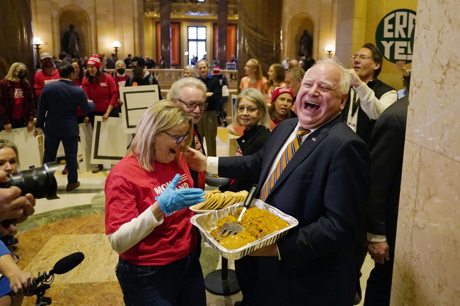 Walz hands out pumpkin bars to a gun safety advocate before the first day of the legislative session in St. Paul in January 2023.