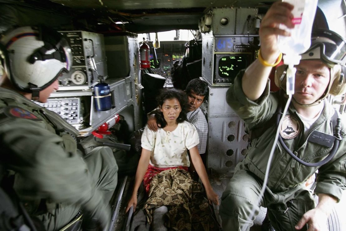 Dos supervivientes del tsunami son trasladados en avión desde una zona devastada de Indonesia por una tripulación de un helicóptero de la Marina de Estados Unidos.