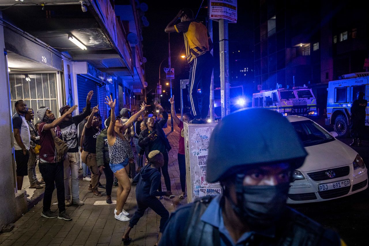 People celebrate as police patrol the streets in Johannesburg, South Africa.